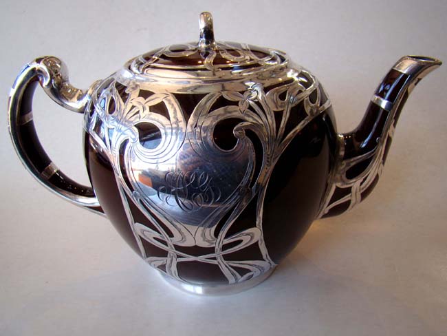 An absolutely stunning scarlet red ceramic teapot with unbelievable silver overlay circa 1890